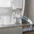 Vue rapprochée d’un WC avec une évacuation en PVC montrant clairement la pente recommandée pour l’évacuation des eaux usées